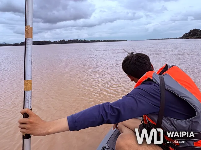 ทีมสำรวจถือเสา GNSS และหัวหยั่งน้ำให้ตั้งดิ่งขณะเรือวิ่ง